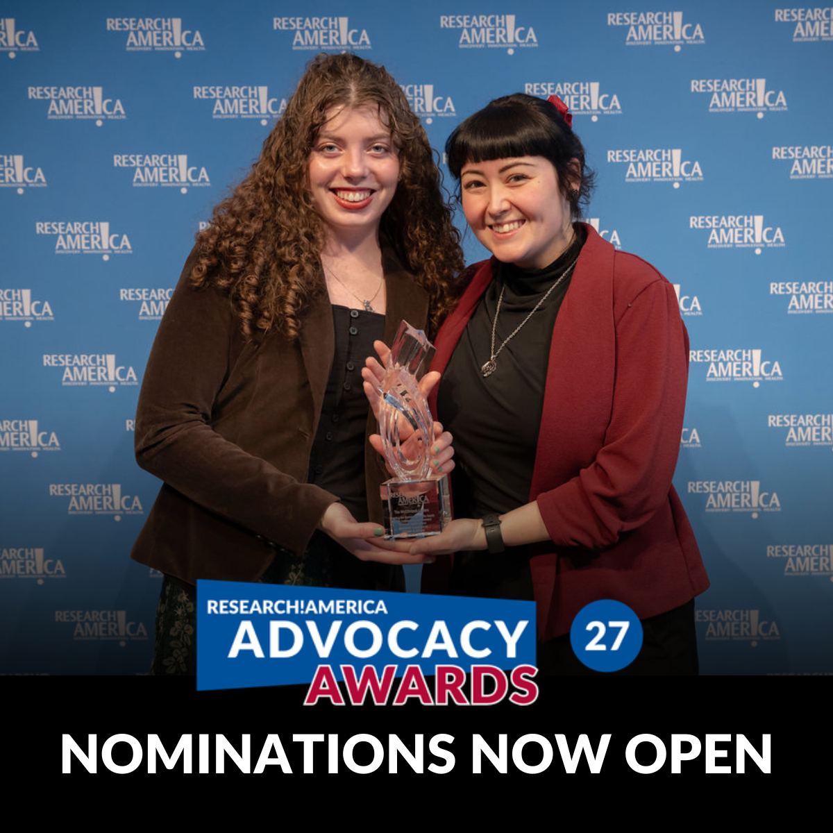 Two smiling individuals stand in front of a blue Research!America step-and-repeat backdrop, holding a glass award together. A graphic overlay reads “Research!America Advocacy Awards,” with a circle displaying “27,” and large text at the bottom states, “Nominations Now Open.”