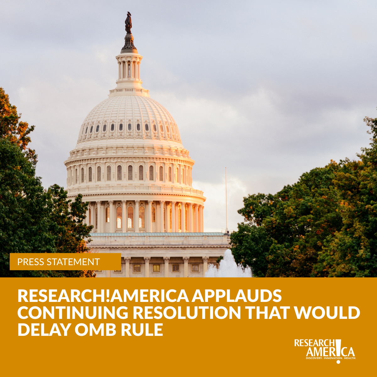 The U.S. Capitol dome is illuminated by warm evening light against a cloudy sky, framed by green trees and a fountain. An orange banner overlays the bottom third of the image with the headline: “Research!America Applauds Continuing Resolution That Would Delay OMB Rule.” A smaller orange label in the upper left reads “Press Statement,” and the Research!America logo appears in the lower right.